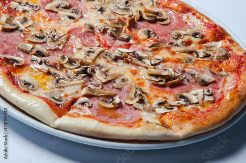 Italian delicious pizza with mushrooms and ham.