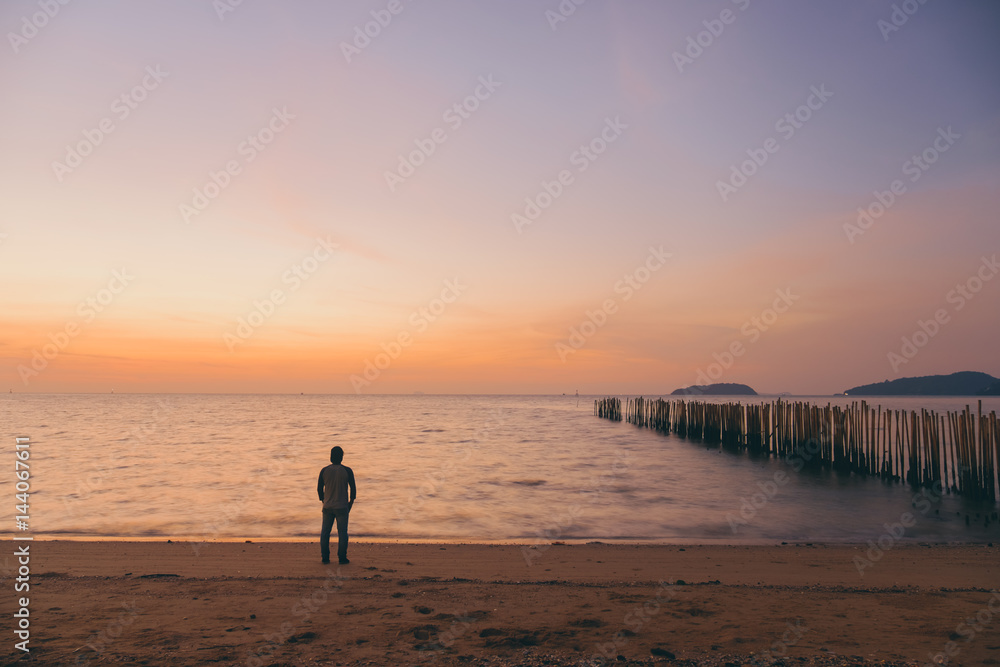 The silhouette of man standing alone at the beach, concept of lonely, sad, alone, person space, alone and scared