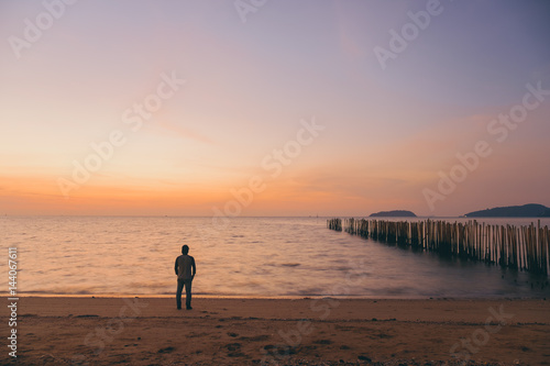 The silhouette of man standing alone at the beach, concept of lonely, sad, alone, person space, alone and scared