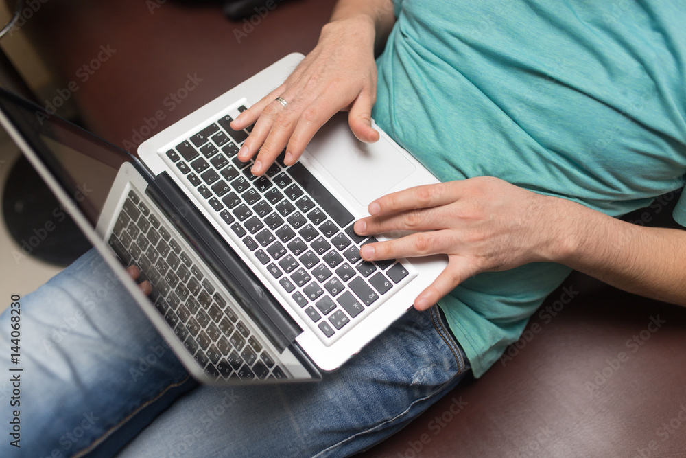 Naklejka premium Hands of a man on a laptop