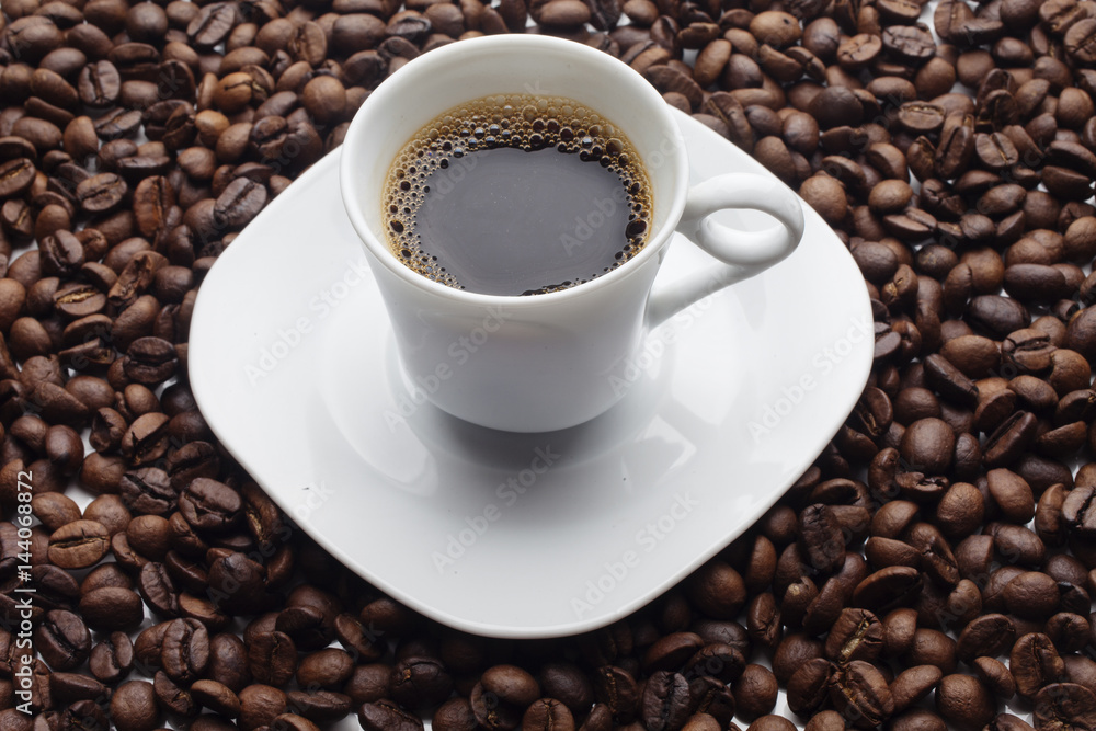 Cup and coffee over beans background Cup and coffee over beans background