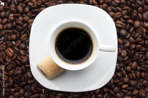 Cup and coffee over beans background © DadoPhotos