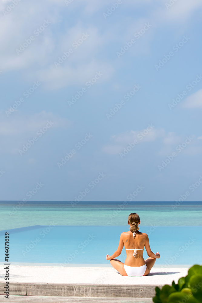 Happy relaxed young woman practicing yoga outdoors at white beach Happy relaxed young woman practicing yoga outdoors at white beach