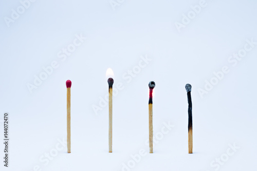 Four matches in a raw erect the first rod is not flammable. Second and third rods ignited. Four rod as charcoal. On white background.