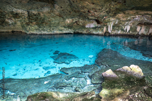 Bright blue cenote - underground waterhole in a lime stone cave. Tulum, Mexico.
