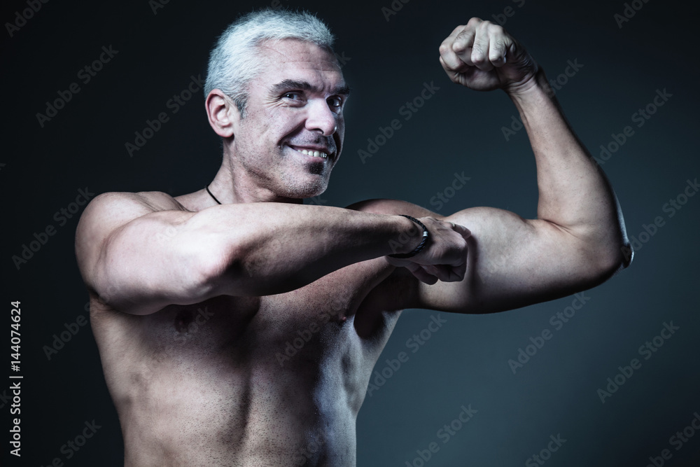 Strong Man Fitness Model showing flexing bicep muscle (Healthy lifestyle, sports, fitness, strength)