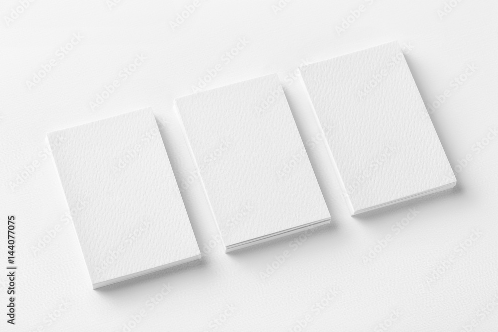 Mockup of three business cards stacks at white textured paper background. Mockup of three business cards stacks at white textured paper background.