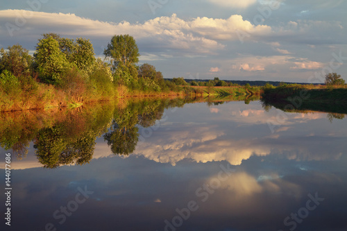 Fototapeta Naklejka Na Ścianę i Meble -  blossoming trees are reflected in the calm waters of the lake