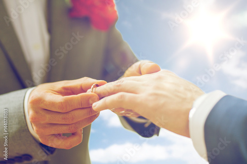 close up of male gay couple hands and wedding ring photo