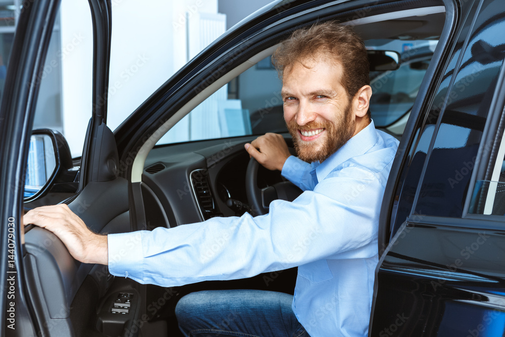 Handsome mature man sitting in a new car Handsome mature man sitting in a new car