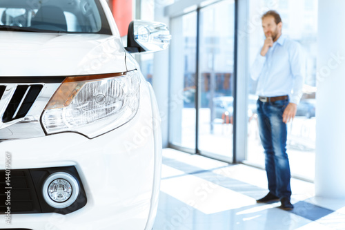 Mature male customer choosing a car at the dealership © Nestor