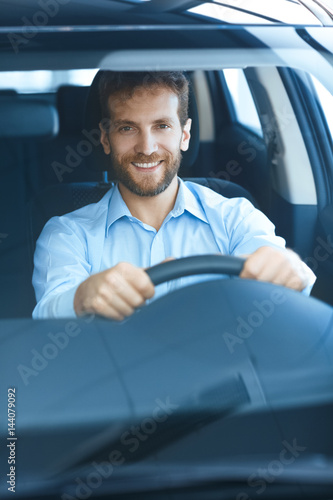 Handsome mature man sitting in a new car