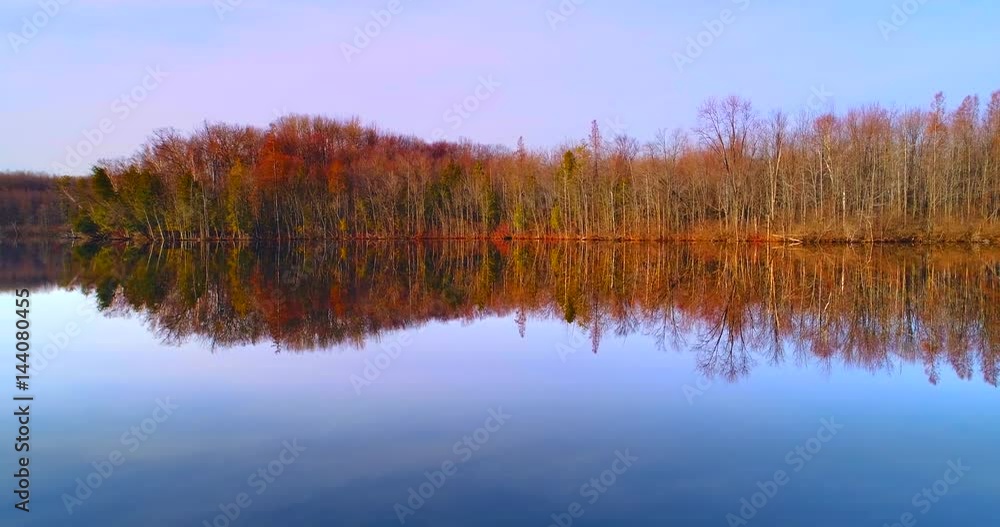 Lilly Lake, Wisconsin, as smooth as a mirror in Springtime, reflections mirroring the world above with perfect clarity, Autumn colors are still evident in the trees. Lilly Lake, Wisconsin, as smooth as a mirror in Springtime, reflections mirroring the world above with perfect clarity, Autumn colors are still evident in the trees.