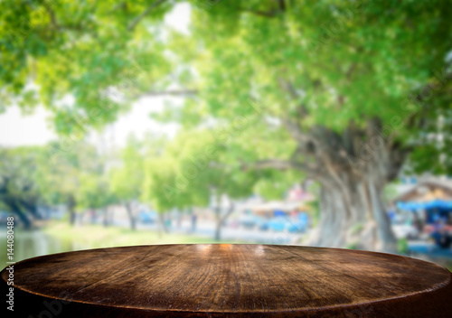 Selected focus empty brown wooden table and green garden or forest blur background with bokeh image. for your photomontage or product display.