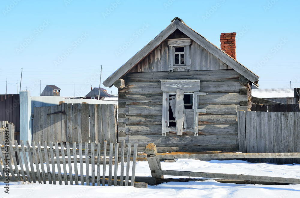 Пустой дом с заколоченным окном зимой