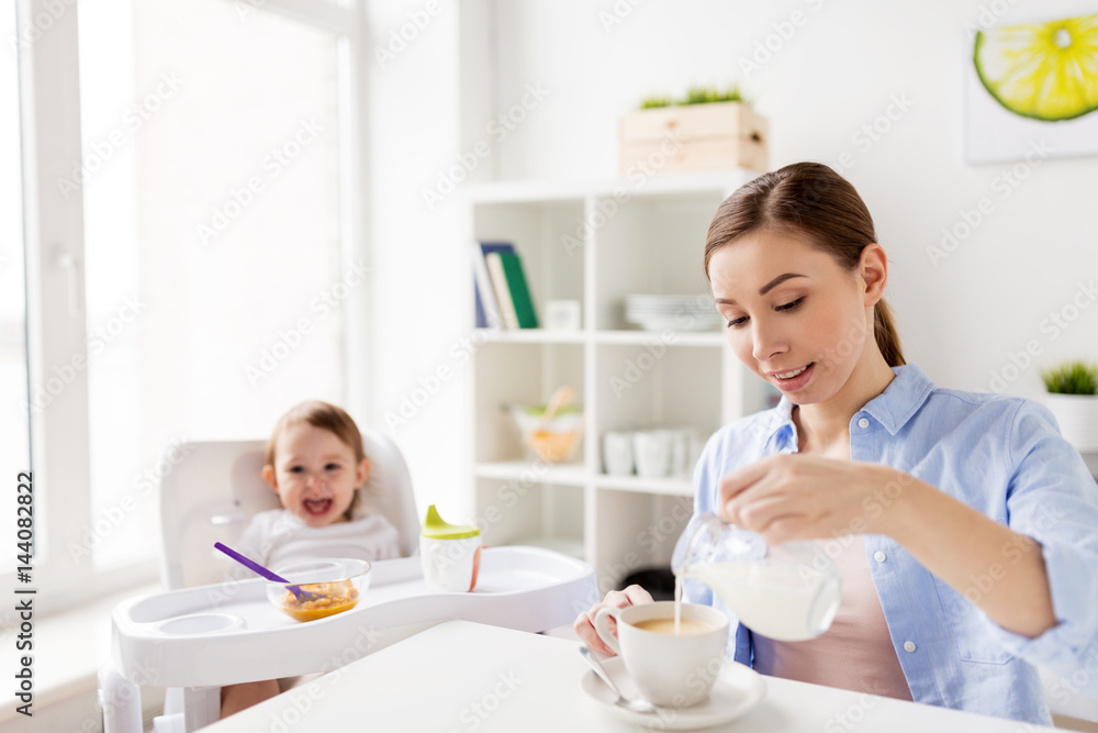 happy mother and baby having breakfast at home