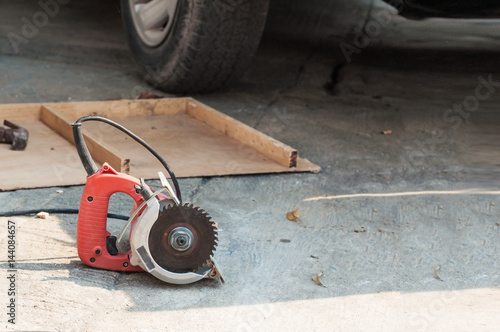 Electric hand held circular saw lay on construction area.