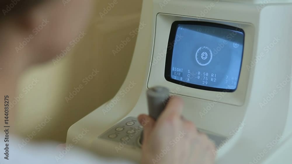 Doctor controling non-contact tonometer at clinic Doctor controling non-contact tonometer at clinic