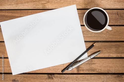 Pencil, Pen, Paper and a cup of black coffee on wooden table