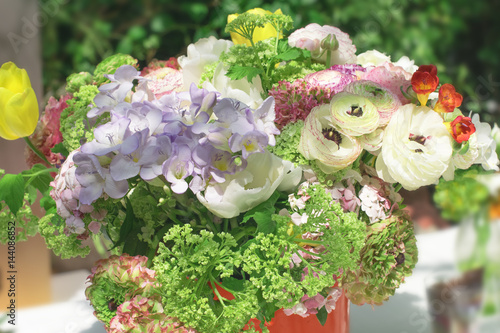 multi-colored bouquet with violet hydrangea, yellow tulips, wild herbs and ranunculus in the flower market