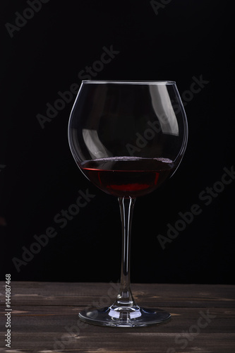 wineglass with wine on black background