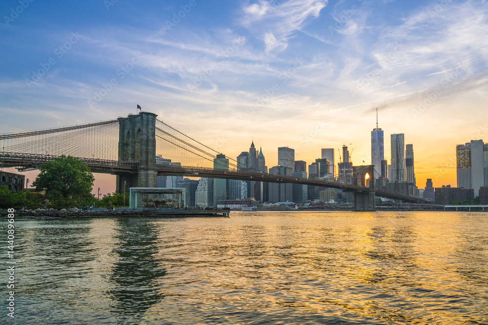 Brooklyn Bridge and Manhattan skyline at dusk, viewed from the East River, New York City Brooklyn Bridge and Manhattan skyline at dusk, viewed from the East River, New York City