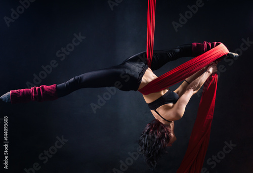The woman is engaged in aerial acrobatics.