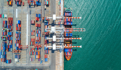 container ship in import export and business logistic.By crane ,Trade Port , Shipping, cargo to harbor, Aerial view, Top view.