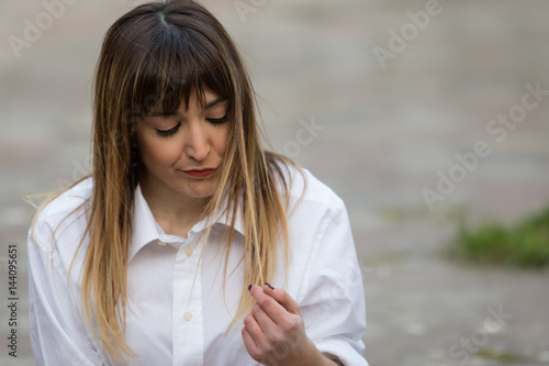 La ragazza che guarda i capelli sfibrati
