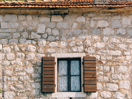 Green window shutters. The facade of houses in Montenegro.