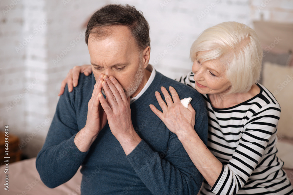 Elderly man sneezing near wife Elderly man sneezing near wife