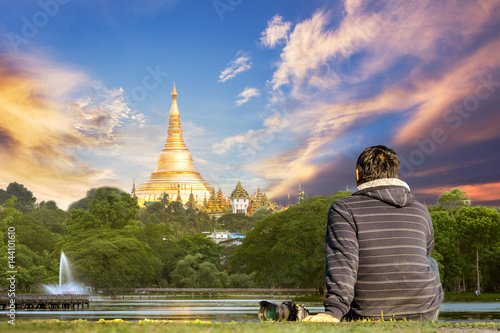 Photographer sit on grass and look for beautiful viewYangon, Myanmar view of Shwedagon Pagoda with sunset time