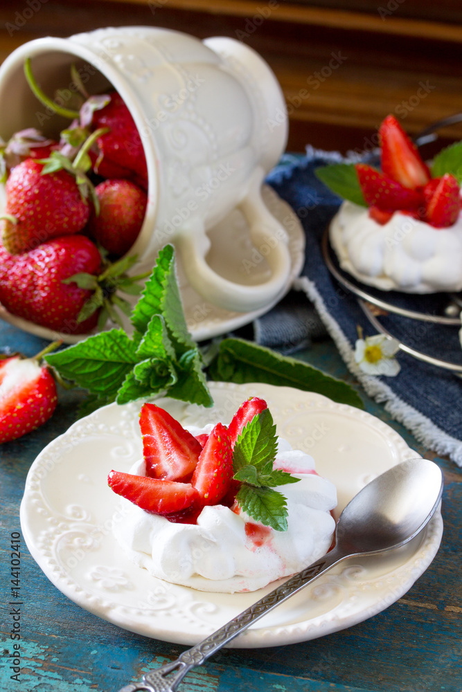 Pavlova meringue pie with fresh strawberries on a vintage blue background. Pavlova meringue pie with fresh strawberries on a vintage blue background.