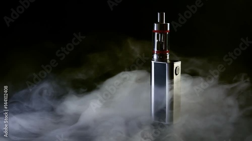 Electronic cigarette close-up on a black background in smoke