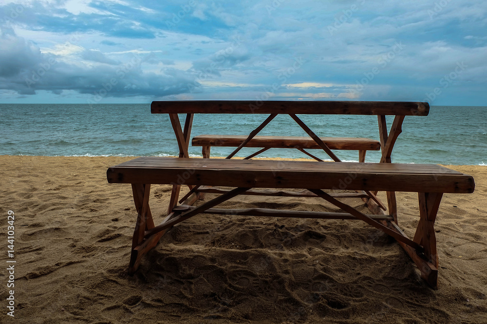 wooden table on the beach in front of sea and sky