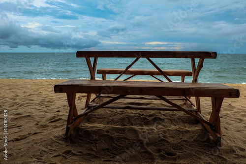 wooden table on the beach in front of sea and sky
