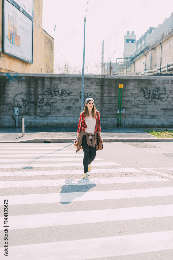 Young beautiful woman walking outdoor in the city - getting away from it all, city living, everyday life concept
