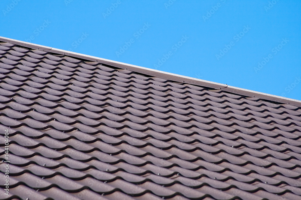 Brown roof of metal roofing on the sky background