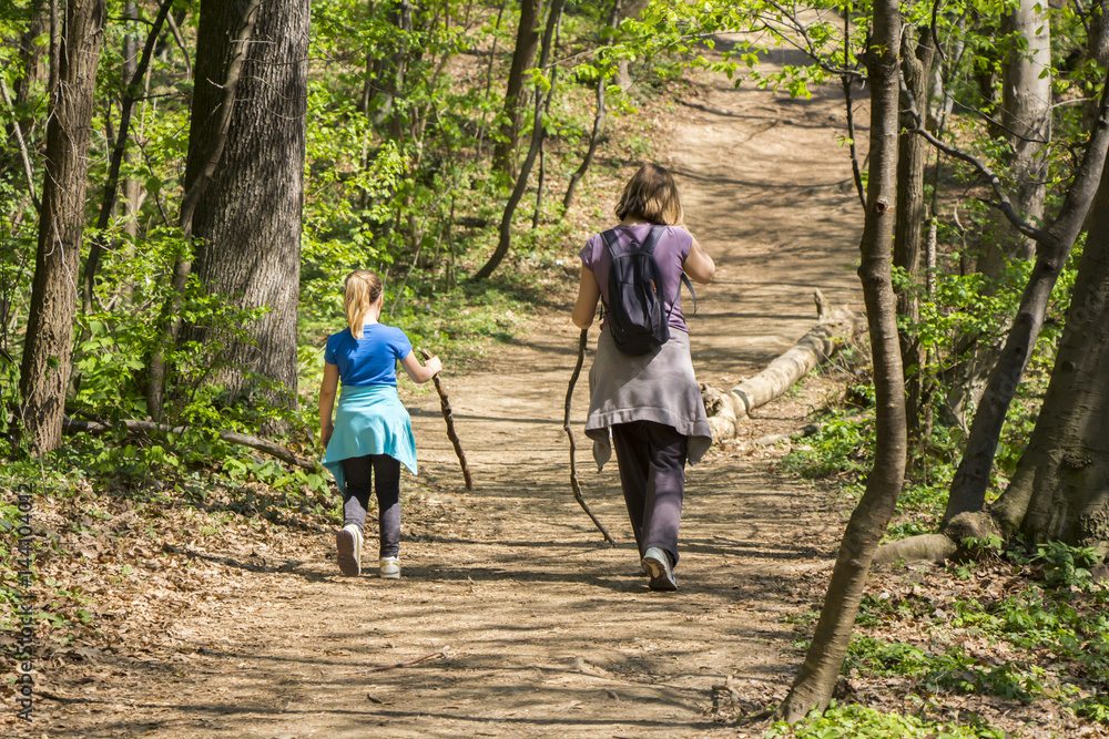Mother and daughter walking in spring forest Mother and daughter walking in spring forest