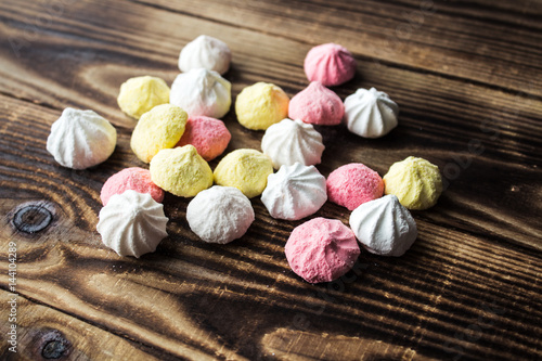 color candy meringue on wooden background