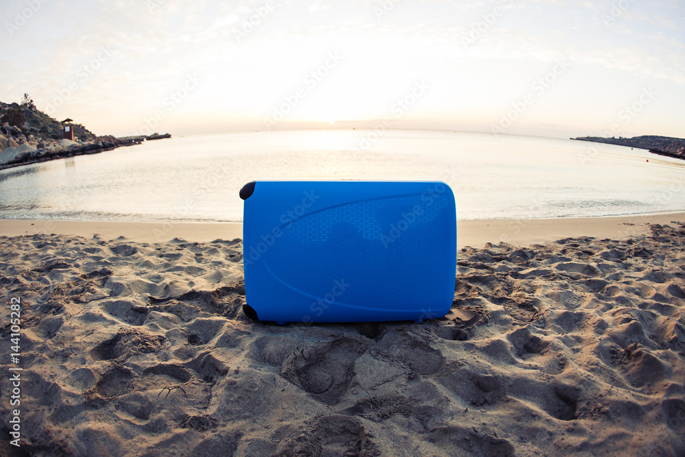 Travel, holiday and vacation concept - blue suitcase on the beach. Travel, holiday and vacation concept - blue suitcase on the beach.