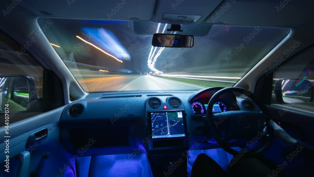 The man drive a car in the city. Left side traffic. Night time. Hyperlapse. Wide angle