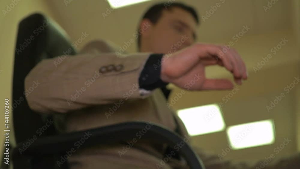 Guy at the workplace dreams about how he drives the car and makes move off hand as if he toggles the gearbox knob Guy at the workplace dreams about how he drives the car and makes move off hand as if he toggles the gearbox knob