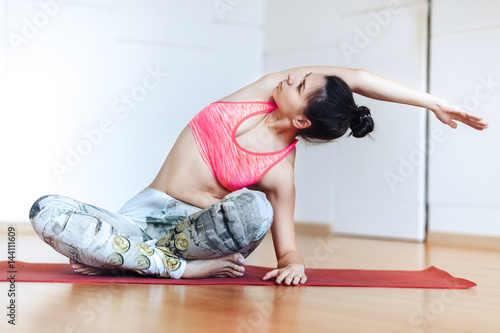 Obraz na płótnie Cute young woman stretching and warming up before working out at a yoga w salonie