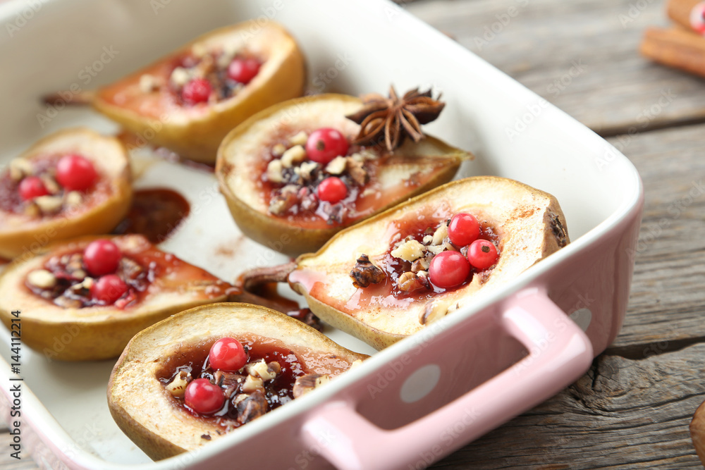 Baked pears with honey, walnuts and cranberries on grey wooden table Baked pears with honey, walnuts and cranberries on grey wooden table