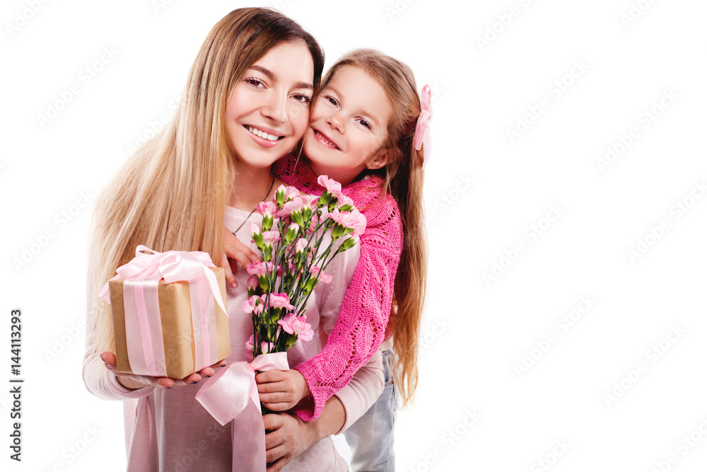 Portrait of happy smiling mother and daughter with bouquet of pink carnations and gift with pink ribbon isolated on white. Happy family. Happy mother's day. Mothers day card. Portrait of happy smiling mother and daughter with bouquet of pink carnations and gift with pink ribbon isolated on white. Happy family. Happy mother's day. Mothers day card.