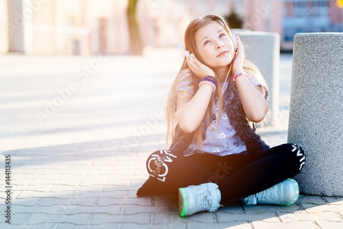 фотографія 10 years old happy girl child listen to the music