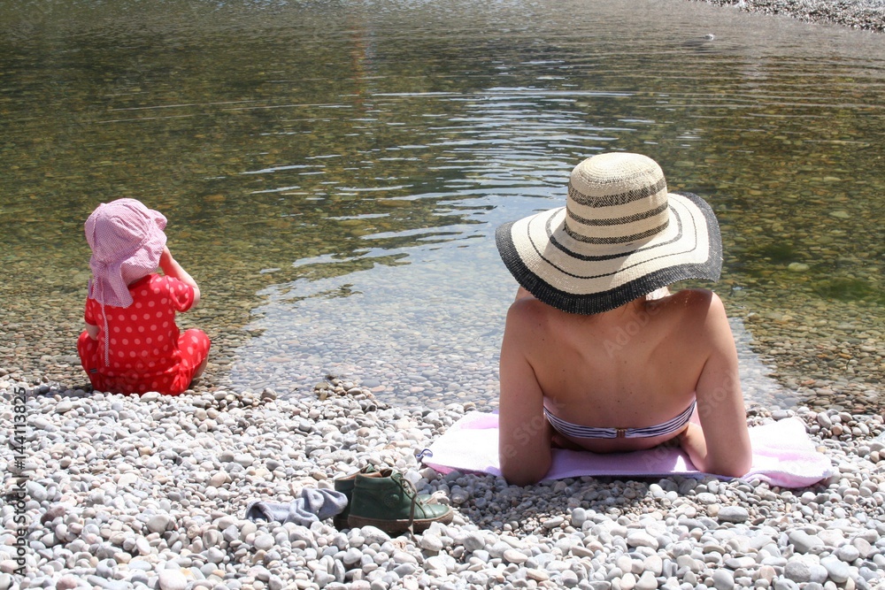 Mutter mit Baby am Steinstrand