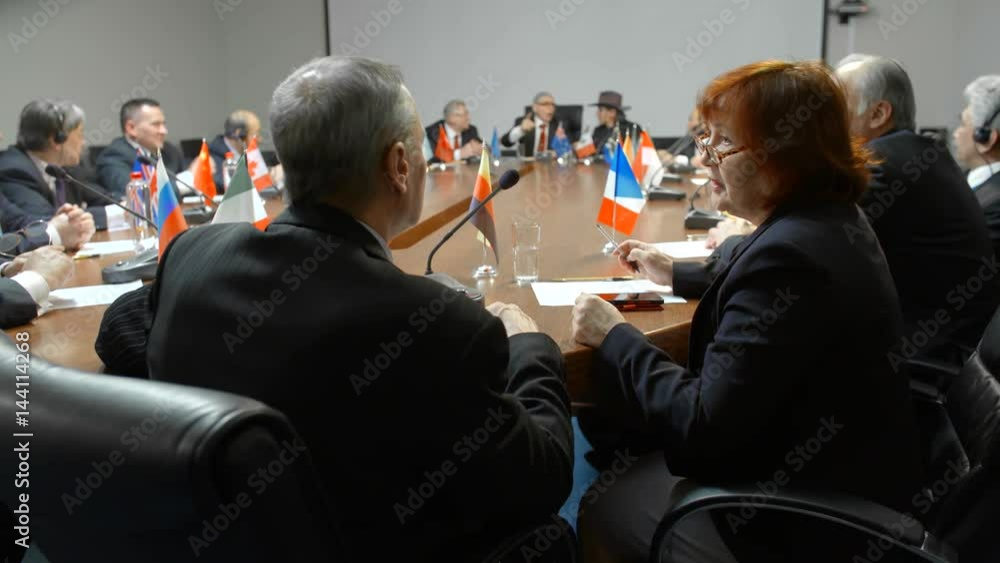 Close shot of US and Germany delegates comfortable and friendly talk at the round table of international meeting. Close shot of US and Germany delegates comfortable and friendly talk at the round table of international meeting.