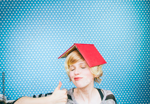 Mujer muy feliz y satisfecha después de estudiar con su libro en la cabeza  photo